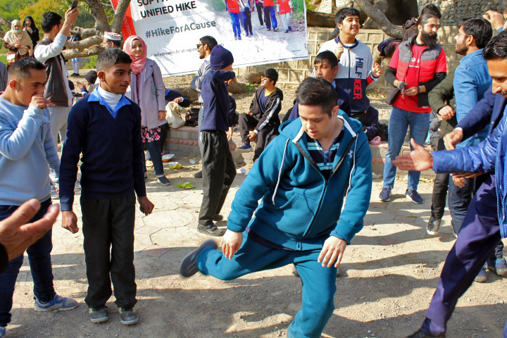 Students breaking out in dance and celebration after a challenging inclusive hike in the hilly mountains in Pakistan